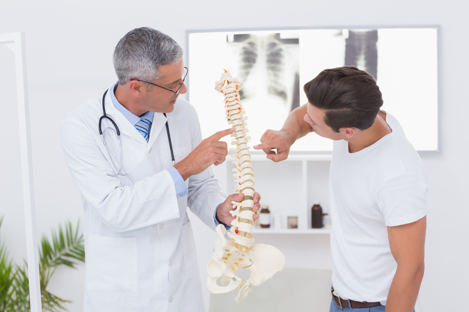 Chiropractor adjusting a patient lying face down on a treatment table in a clinic