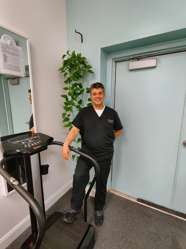 Person lying on a spinal decompression table in a clinic, with medical equipment nearby.