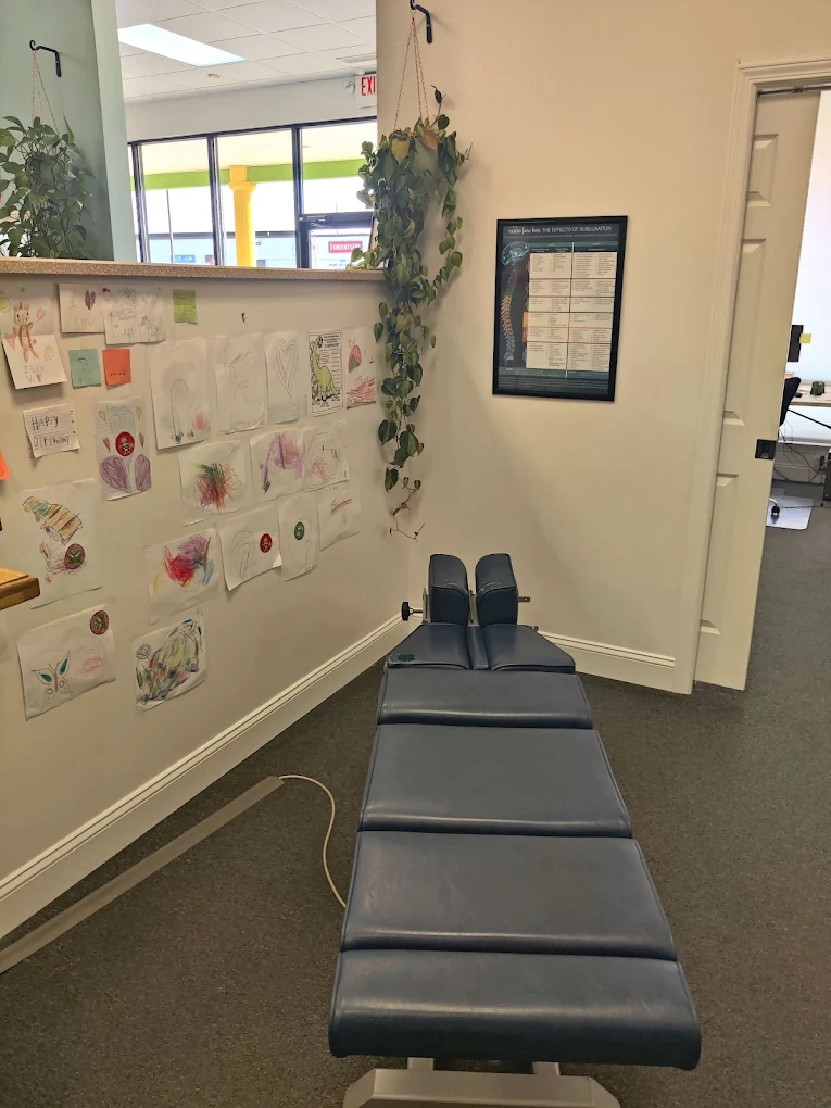 Chiropractor adjusting a patient lying face down on a treatment table in a clinic