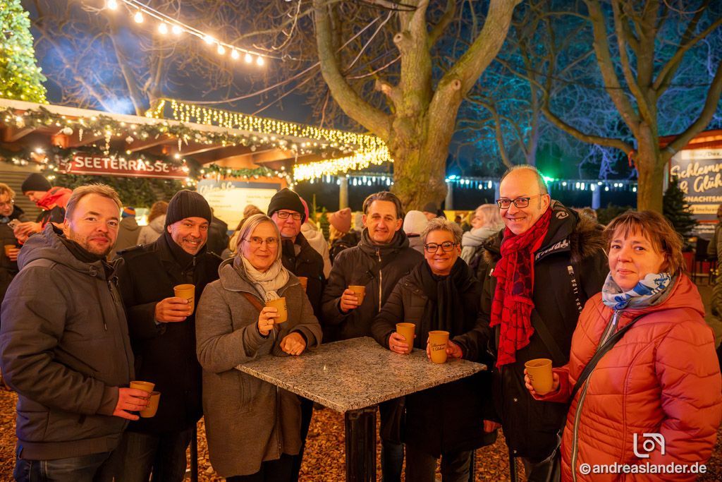 Weihnachtsmarkt Atmosphäre mit Lichtern und Ständen am Abend.