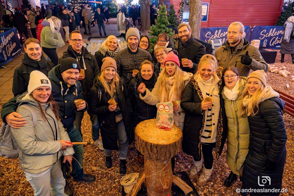 Weihnachtsfeier mit Essen und Baumstammnageln als Aktivität.