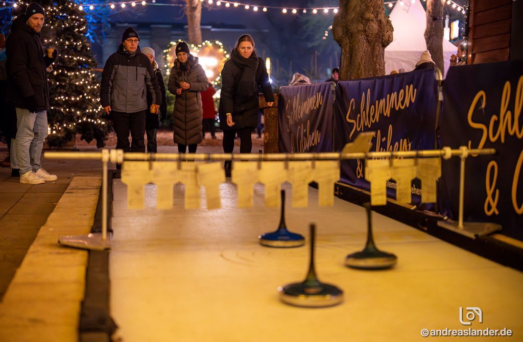 Weihnachtsfeier am See in Magdeburg mit Lichtern und Eisstockschießen.