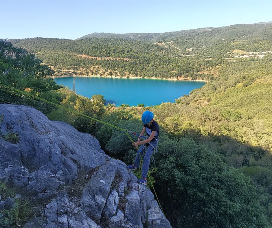 Un jeune garçon qui grimpe une montagne en sécurité