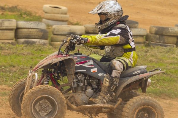 Un adolescent fait du quad sur un terrain aménagé dans la nature