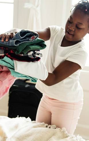 enfant préparant sa valise pour la colonie de vacances