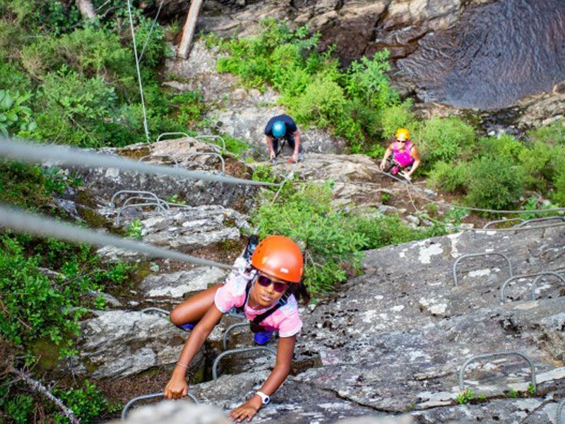 Des enfants font une sortie escalade en extérieur sur des parois naturelles