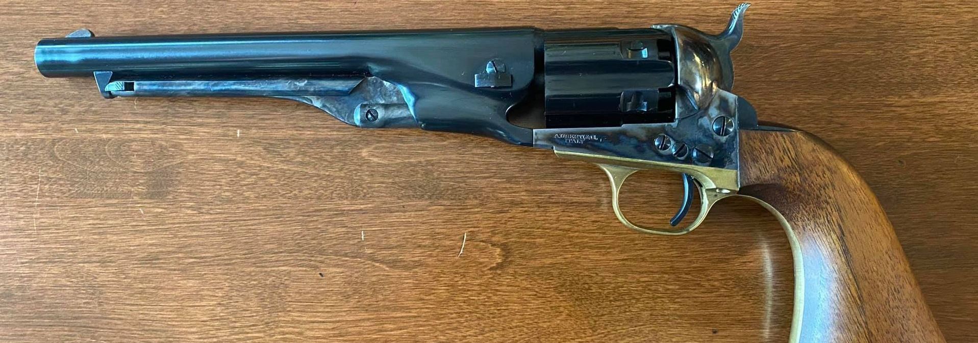 Black and gold revolver on a wooden surface.