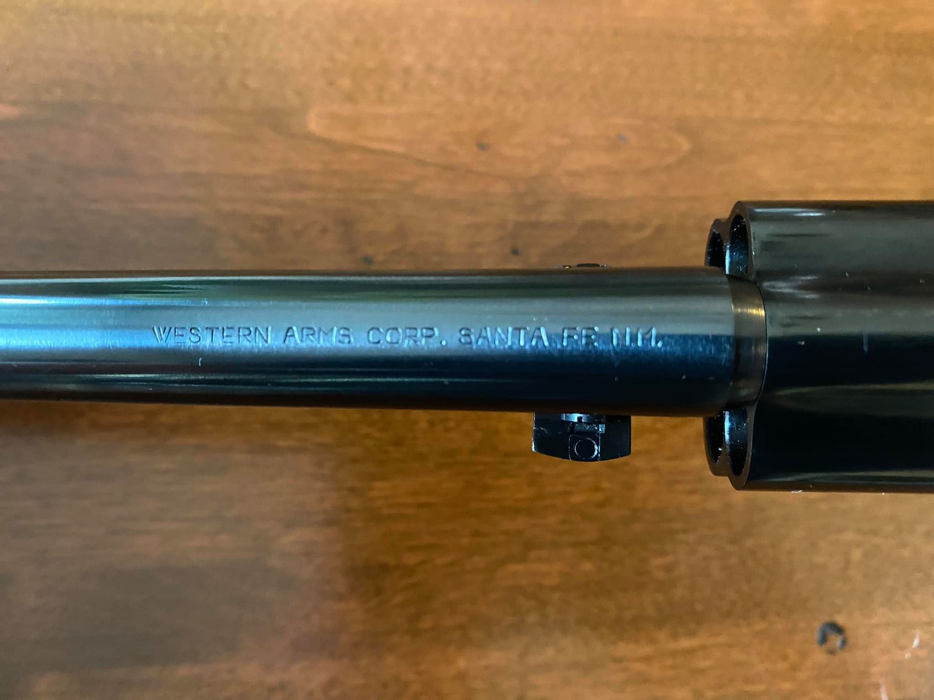 Close-up of a black revolver barrel with white text reading