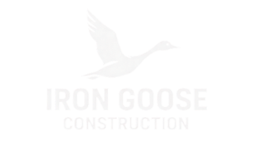 Iron Goose Construction logo with a faint flying goose silhouette on a white background
