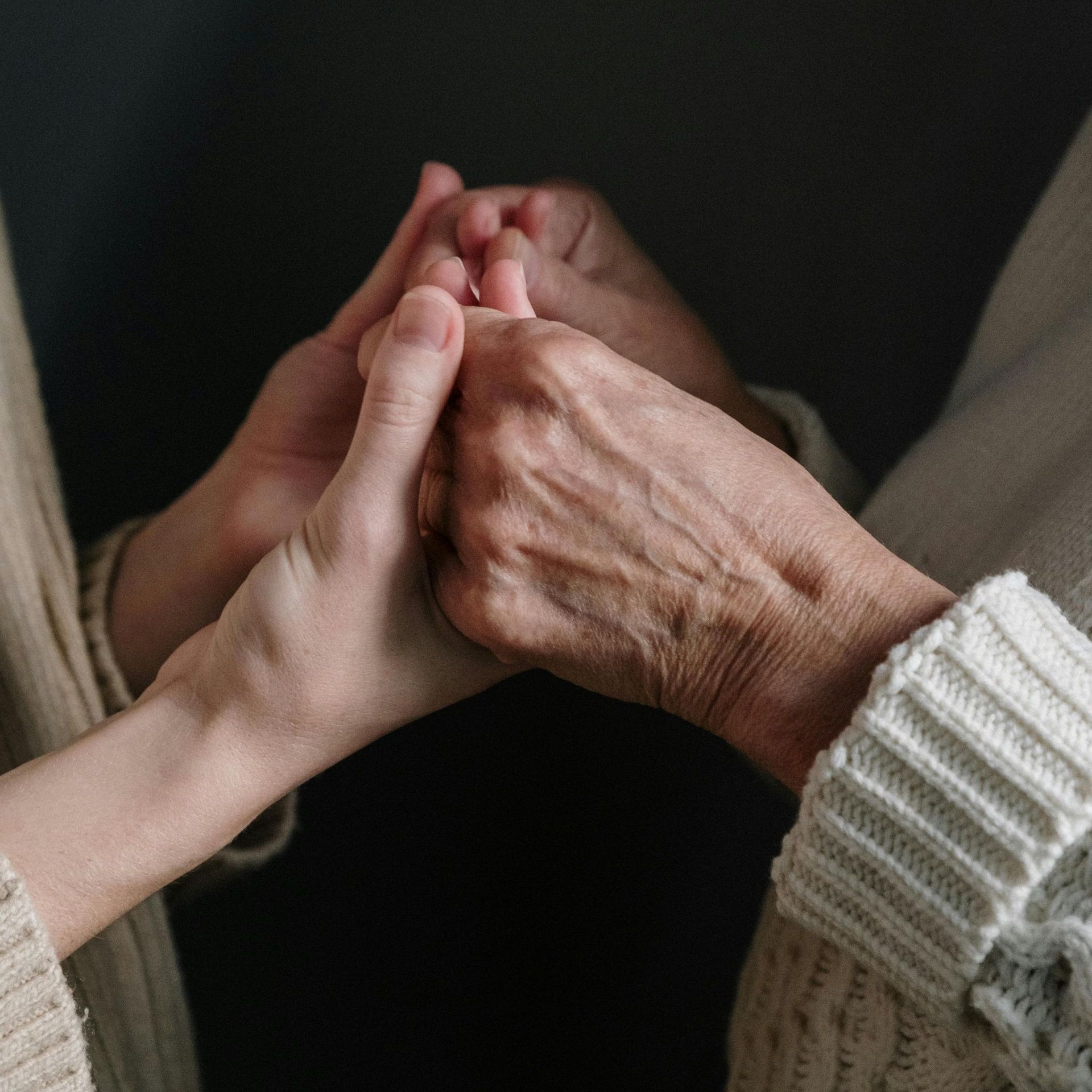 A close up of a person holding another person 's hand.