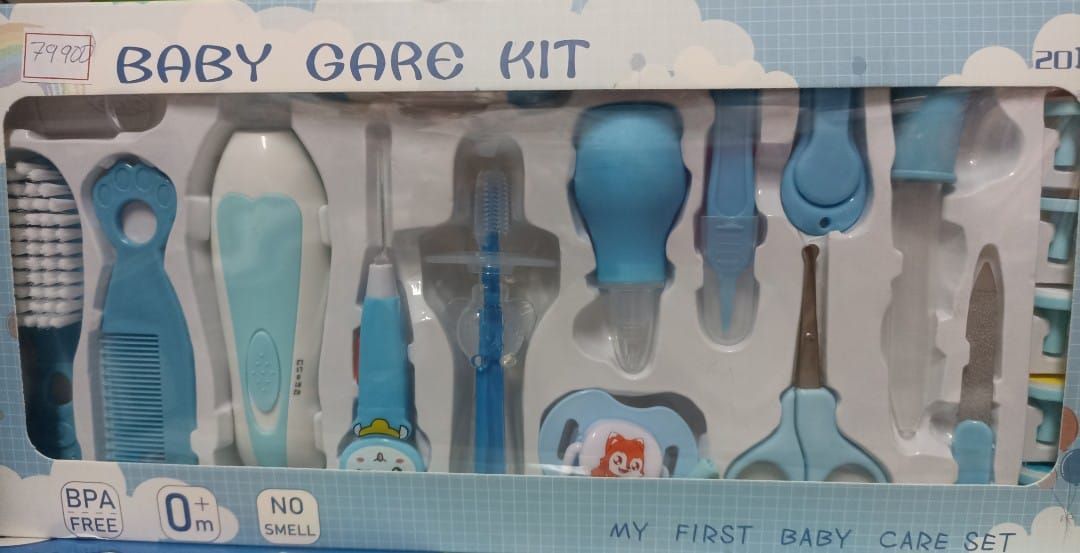 Kit azul para el cuidado del bebé en una caja transparente con termómetro, jeringa, peine y otros utensilios de aseo.