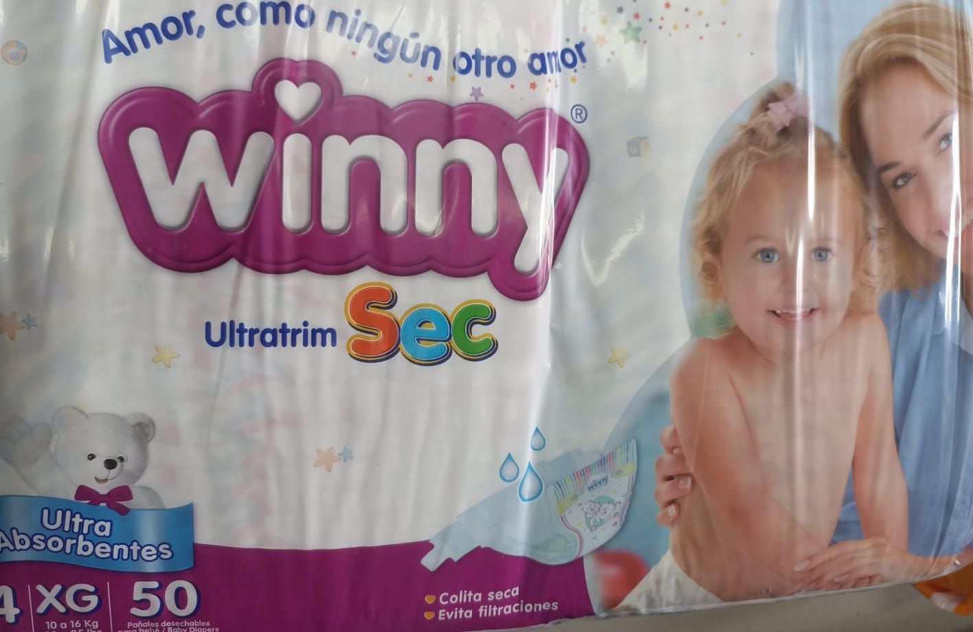 Paquete de pañales Winny Ultrafin Sec con foto de bebé, diseño blanco y morado, en texto portugués