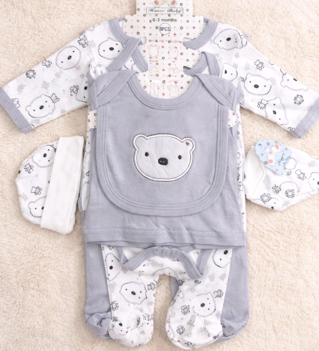 Conjunto de ropa infantil en gris y blanco con temática de oso, compuesto por un body de manga larga, un pelele, pantalones