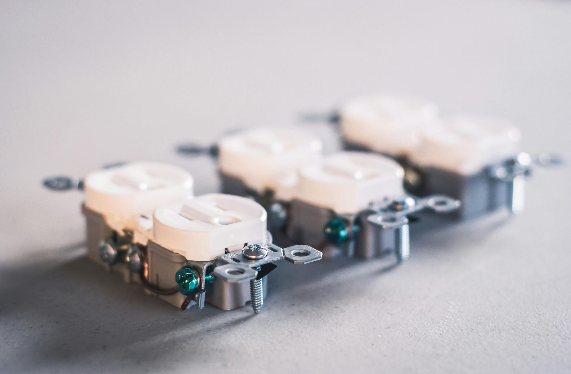 Three small white electronic devices on a gray surface, shown in shallow focus