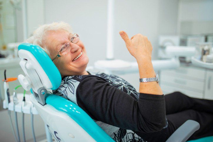 elder woman smiling with thumbs up