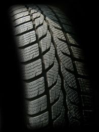 Close-up of a black tire with a textured tread pattern.