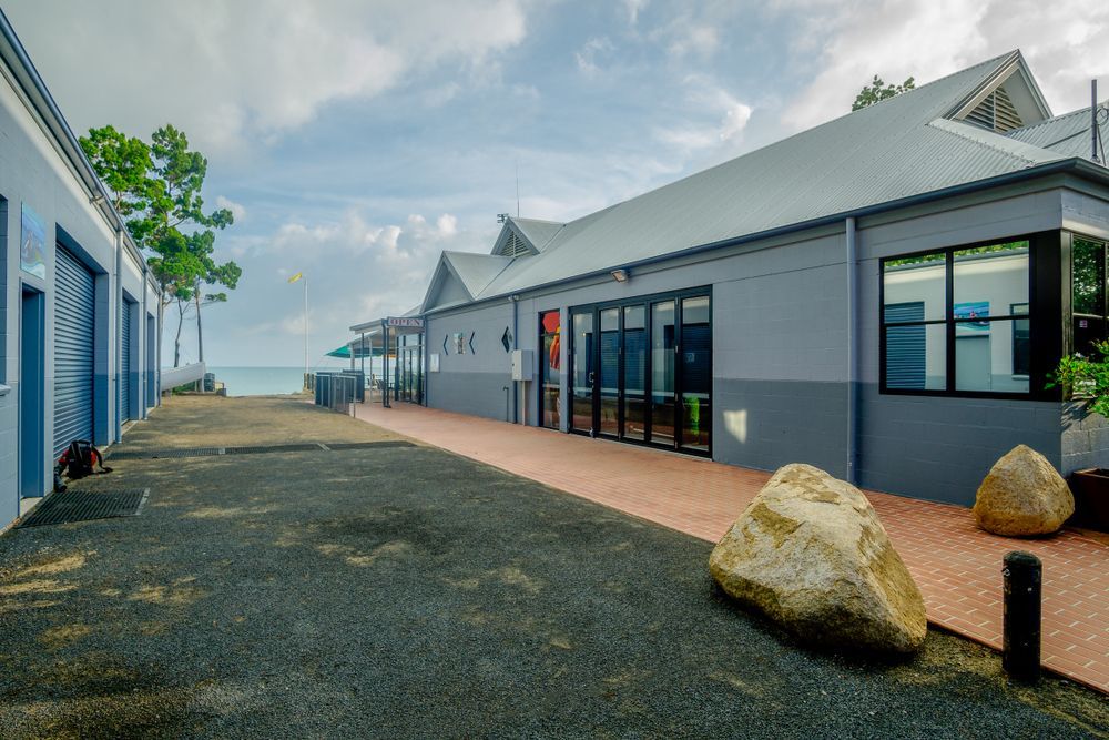 A Large Building With A Lot Of Windows And A Large Rock In Front Of It — Australian Rock Walls In Hervey Bay, QLD