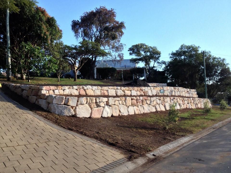 A Stone Wall Along The Side Of A Road — Australian Rock Walls In Burleigh Heads, QLD