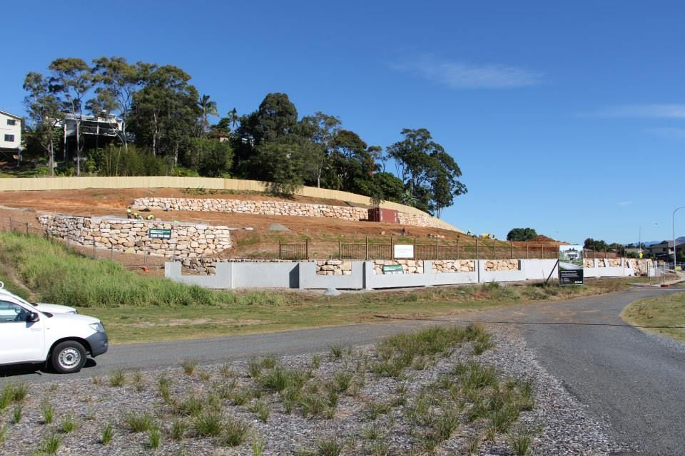A White Car Is Parked On The Side Of A Road — Australian Rock Walls In Goonellabah, NSW