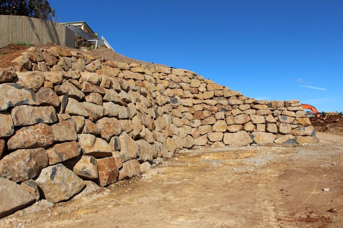 A Large Pile Of Rocks Is Sitting On Top Of A Dirt Hill — Australian Rock Walls In Gold Coast, QLD