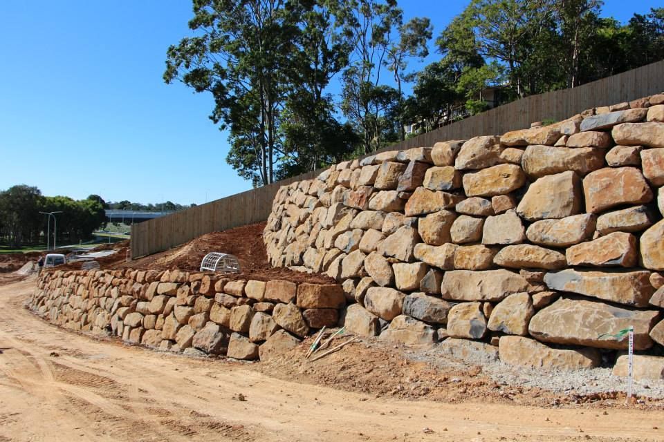 A Large Rock Wall Is Being Built On The Side Of A Dirt Road — Australian Rock Walls In Burleigh Heads, QLD