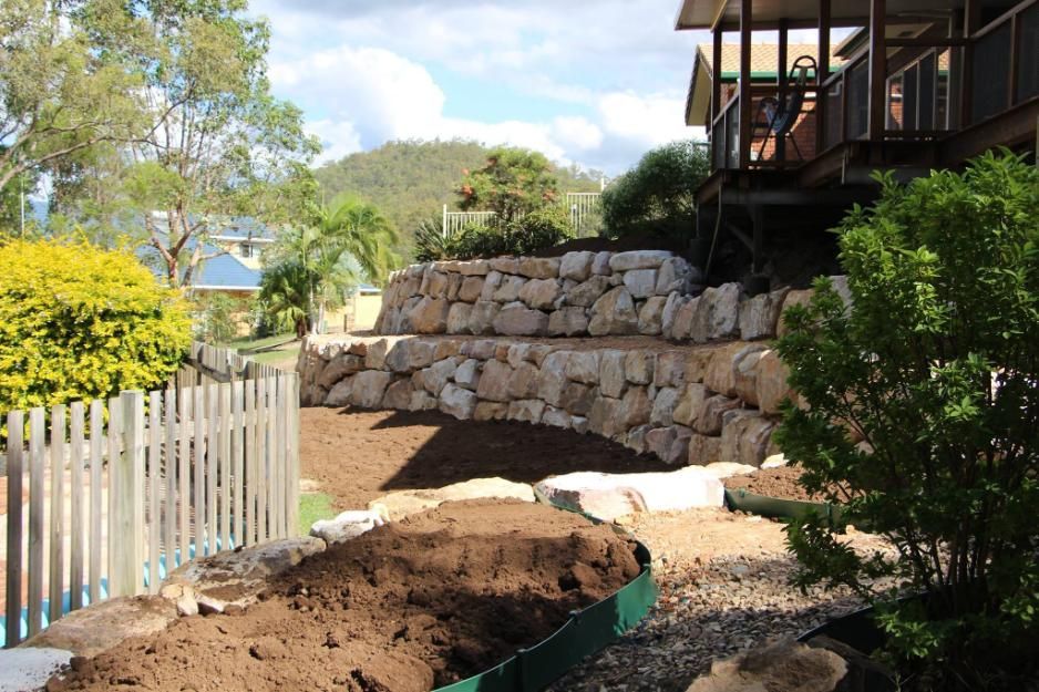 A Large Pile Of Dirt Is Sitting In Front Of A House — Australian Rock Walls In Beechmont, QLD