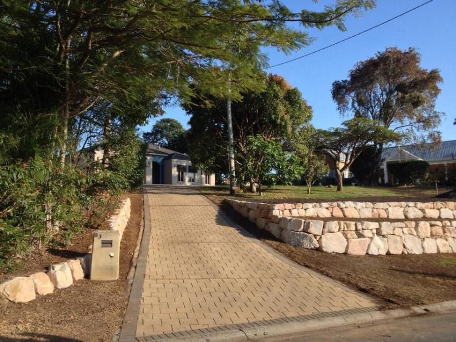 A Brick Driveway Leading To A House With Trees On Both Sides — Australian Rock Walls In Gold Coast, QLD