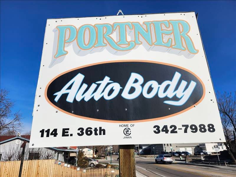 Sign for Portner Auto Body, white with blue and black text. Address and phone number included.