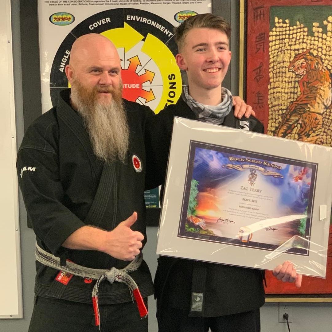 BJJ instructor and student celebrating a victory, both with broad smiles