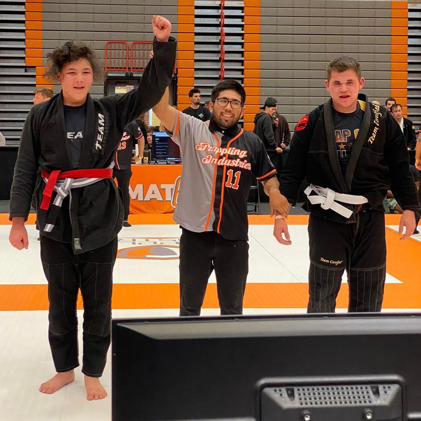 BJJ instructor awarding a new belt to a proud student