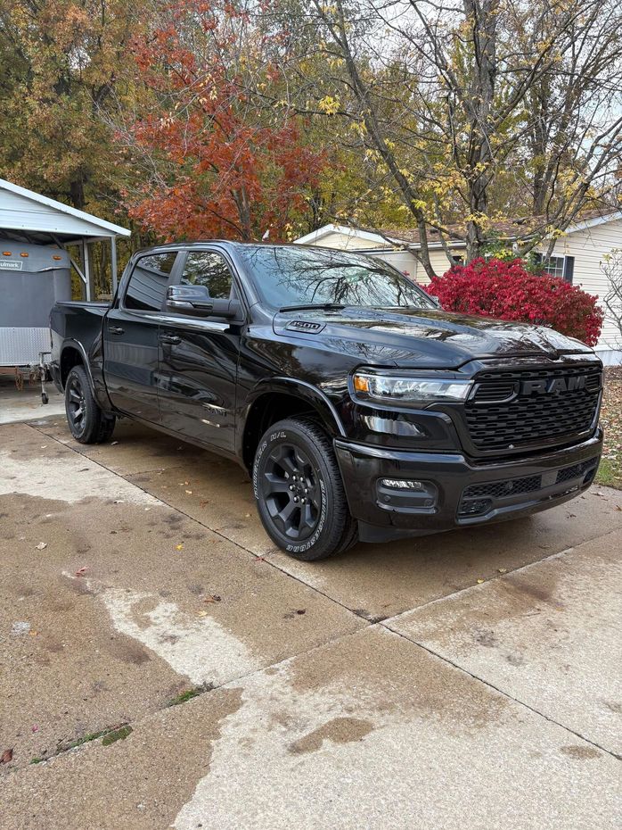Black Ram truck parked outside on concrete.