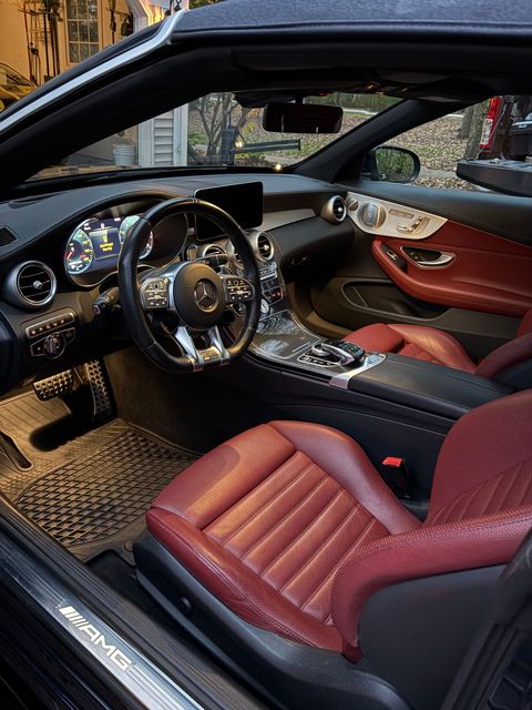 Interior view of a BMW car, featuring a black leather steering wheel, dashboard, and center console.