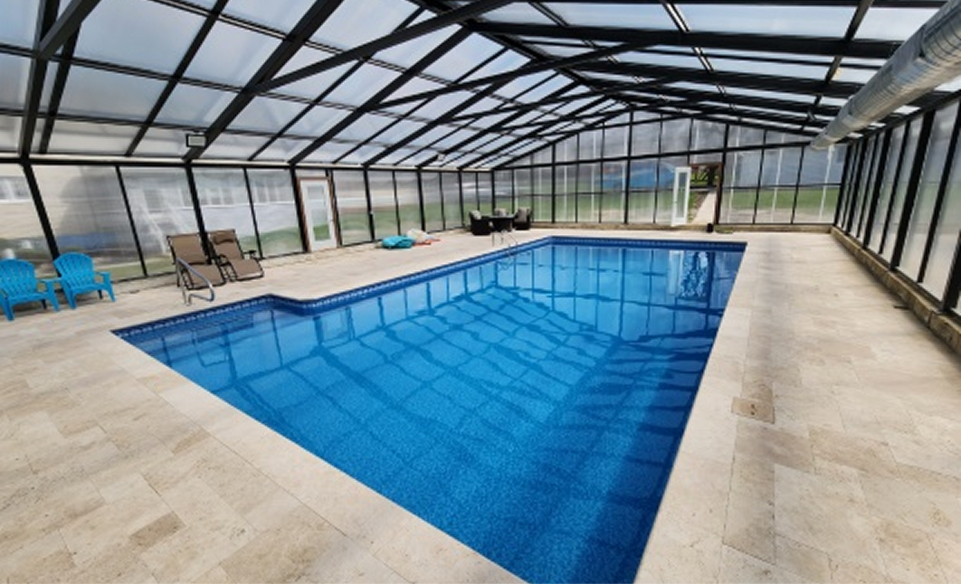 Blue mosaic swimming pool with a white diving board and steps at the far end