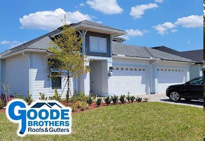 A white single-story residential home with a three-car garage and a blue Goode Brothers Roofs & Gutters logo in the corner.