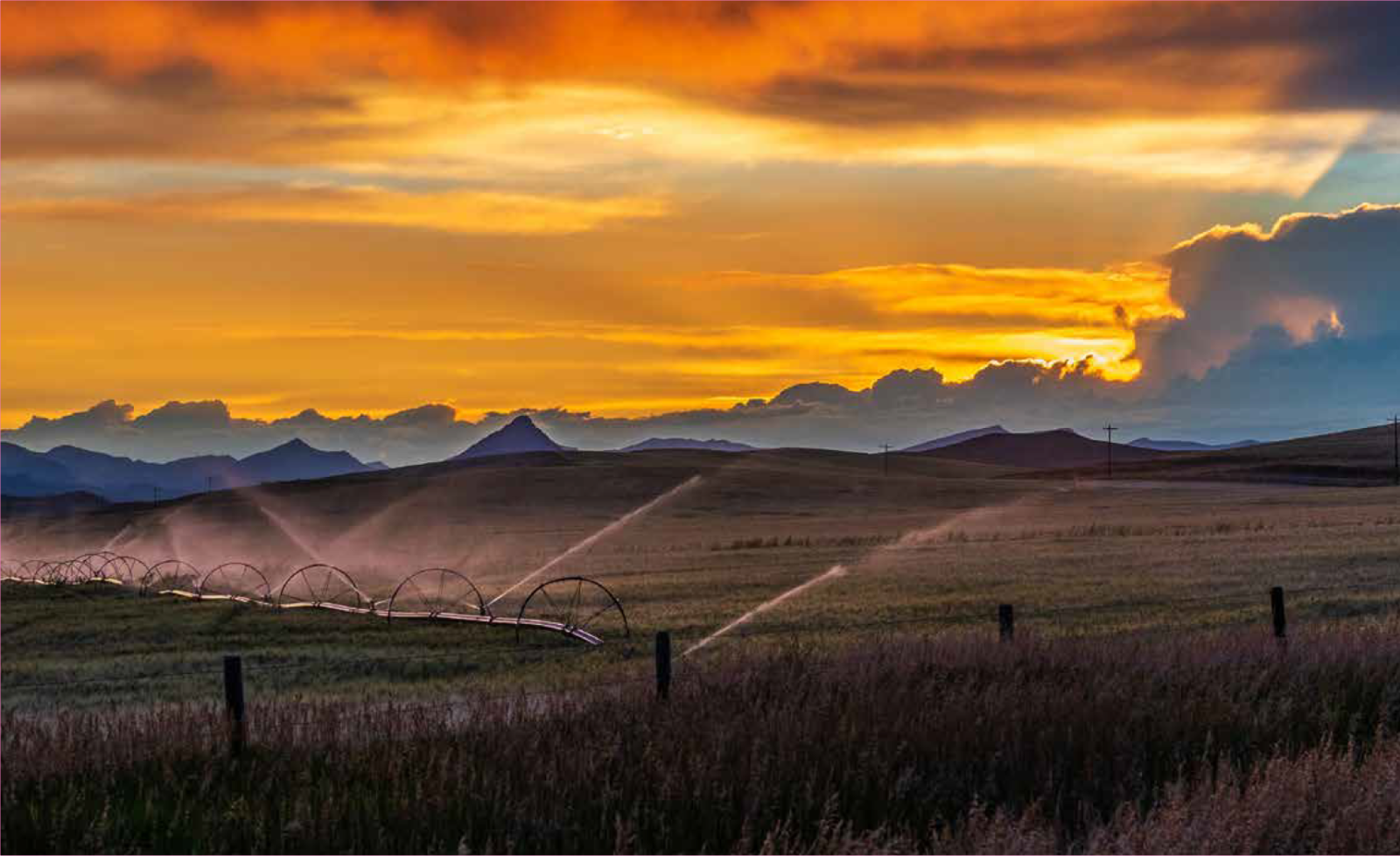 Sunset Over Mountain Peaks and Rolling Fields, With Orange Clouds — Taree Water Works in Taree, NSW