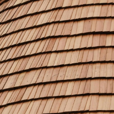 Wooden cedar roof shingles, overlapping in rows.
