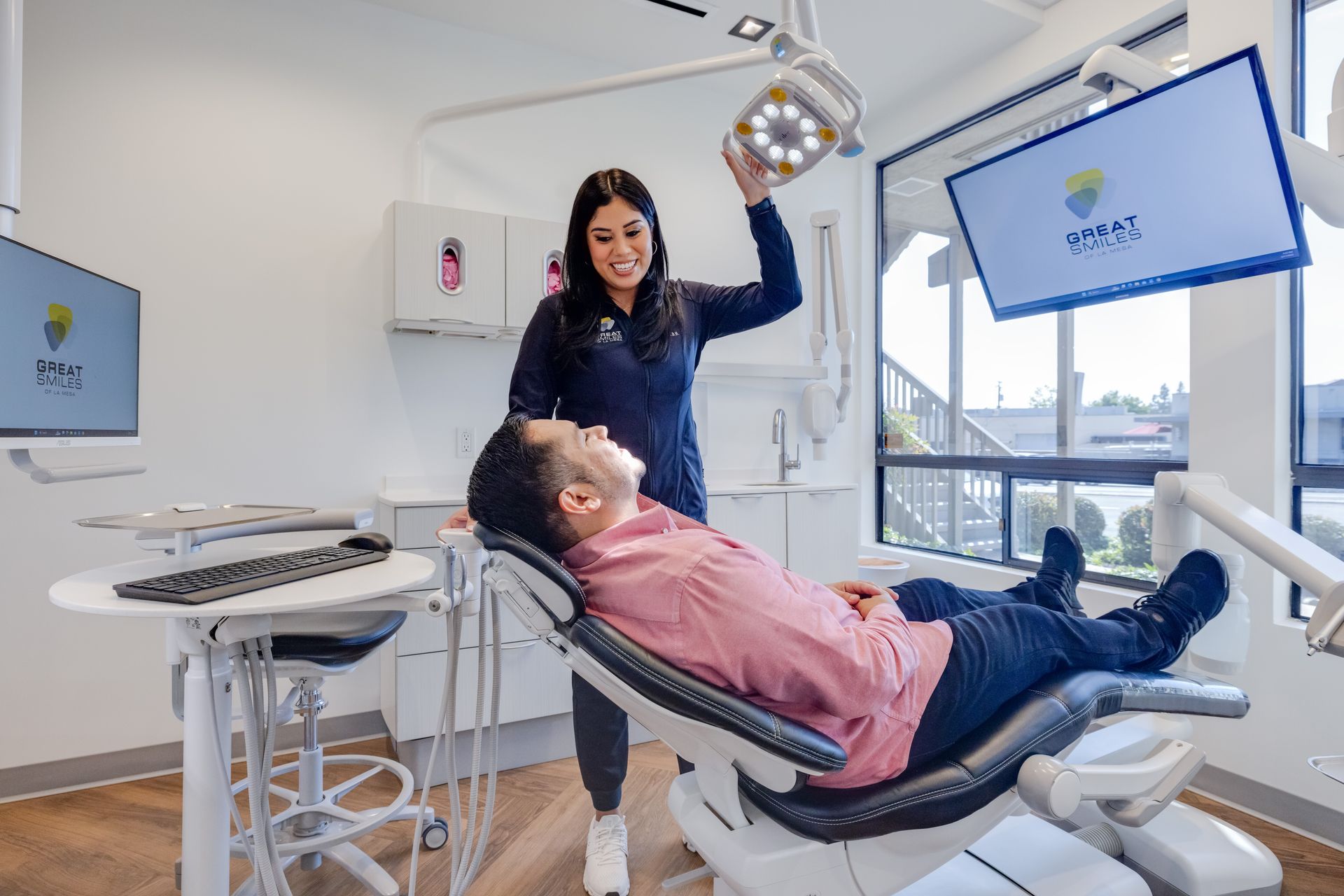 Dentist adjusts light for patient in a modern dental office.