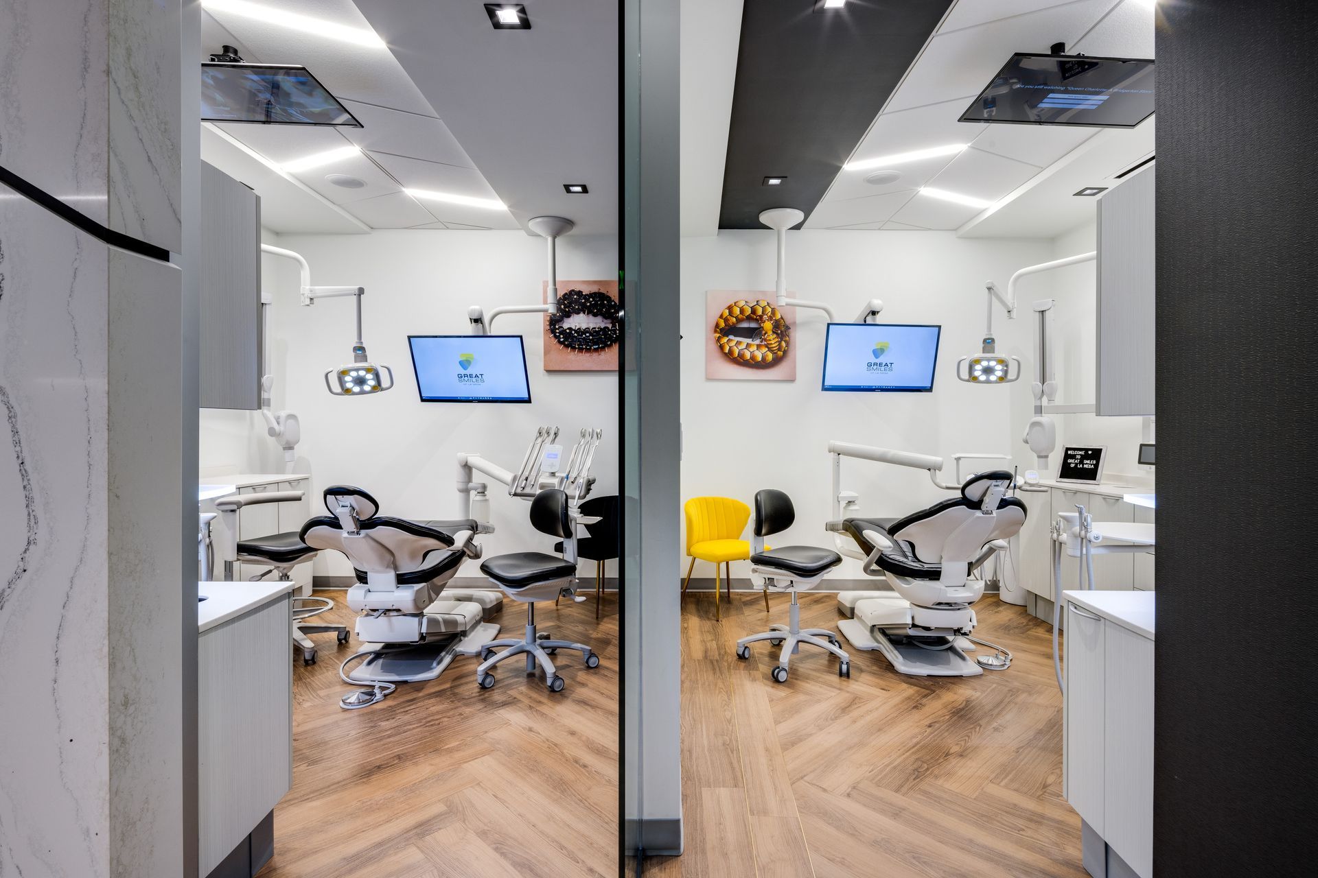A dental office with a lot of chairs and monitors.