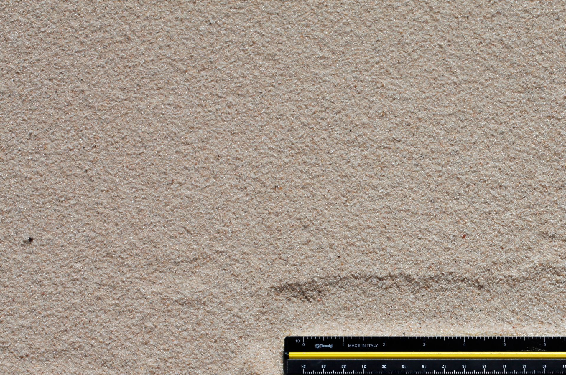 A ruler is next to a piece of sand