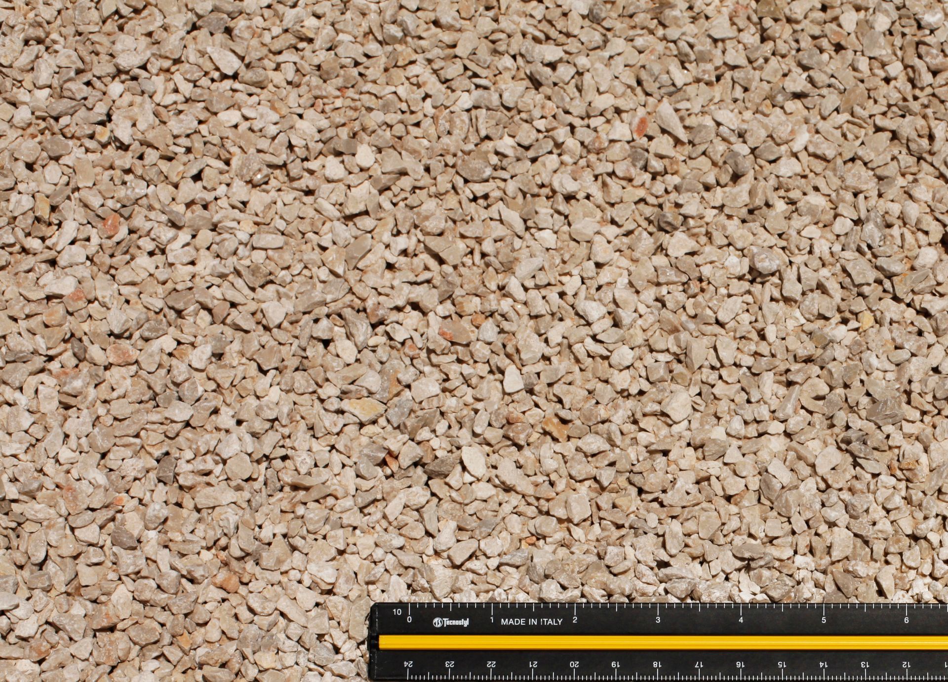 A ruler is sitting on top of a pile of gravel.