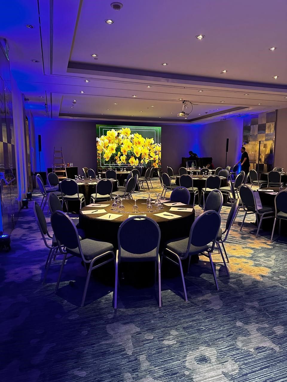 Una gran sala con mesas y sillas preparadas para un banquete.