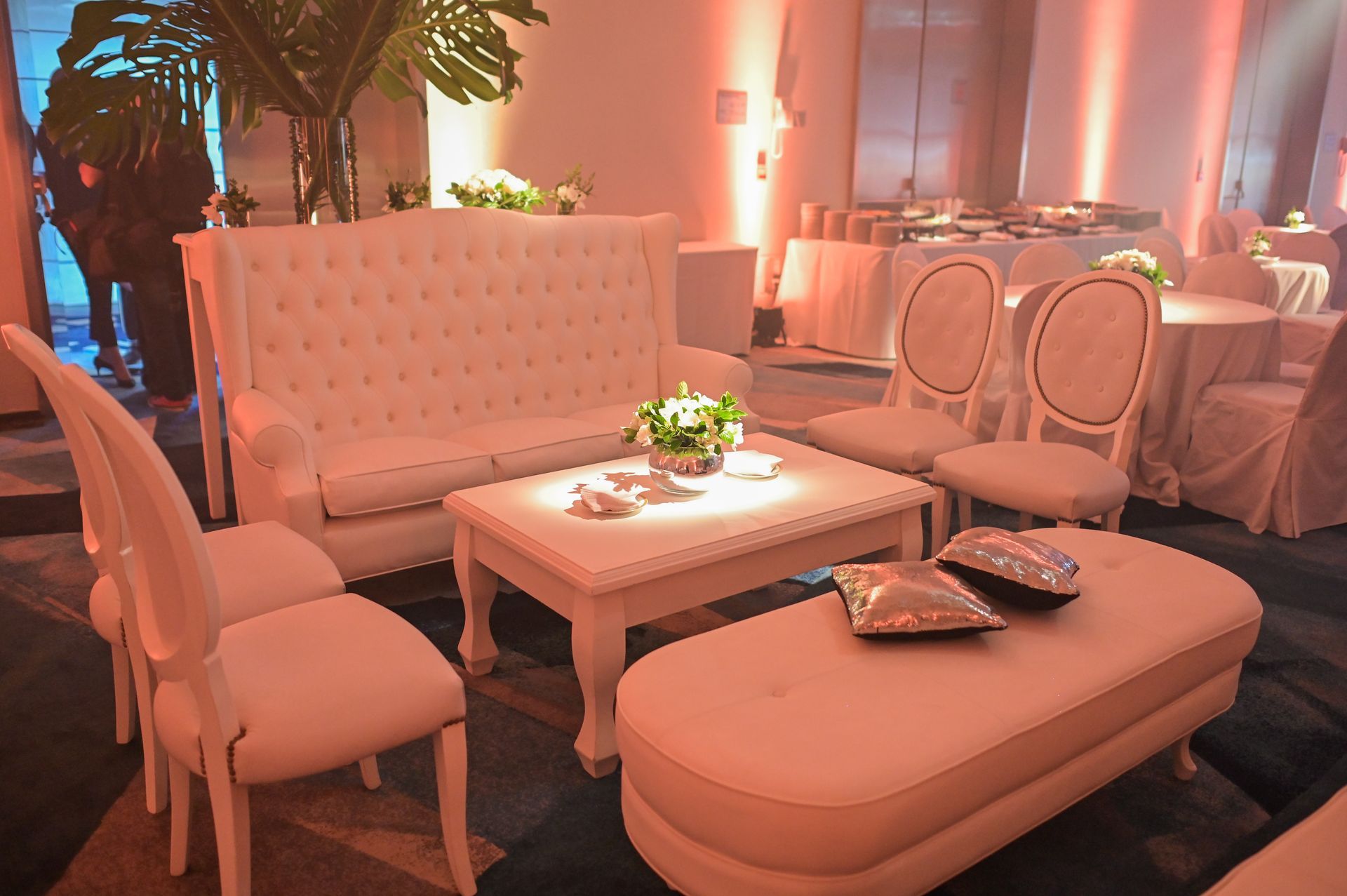 Una habitación con muebles blancos y mesas y sillas.