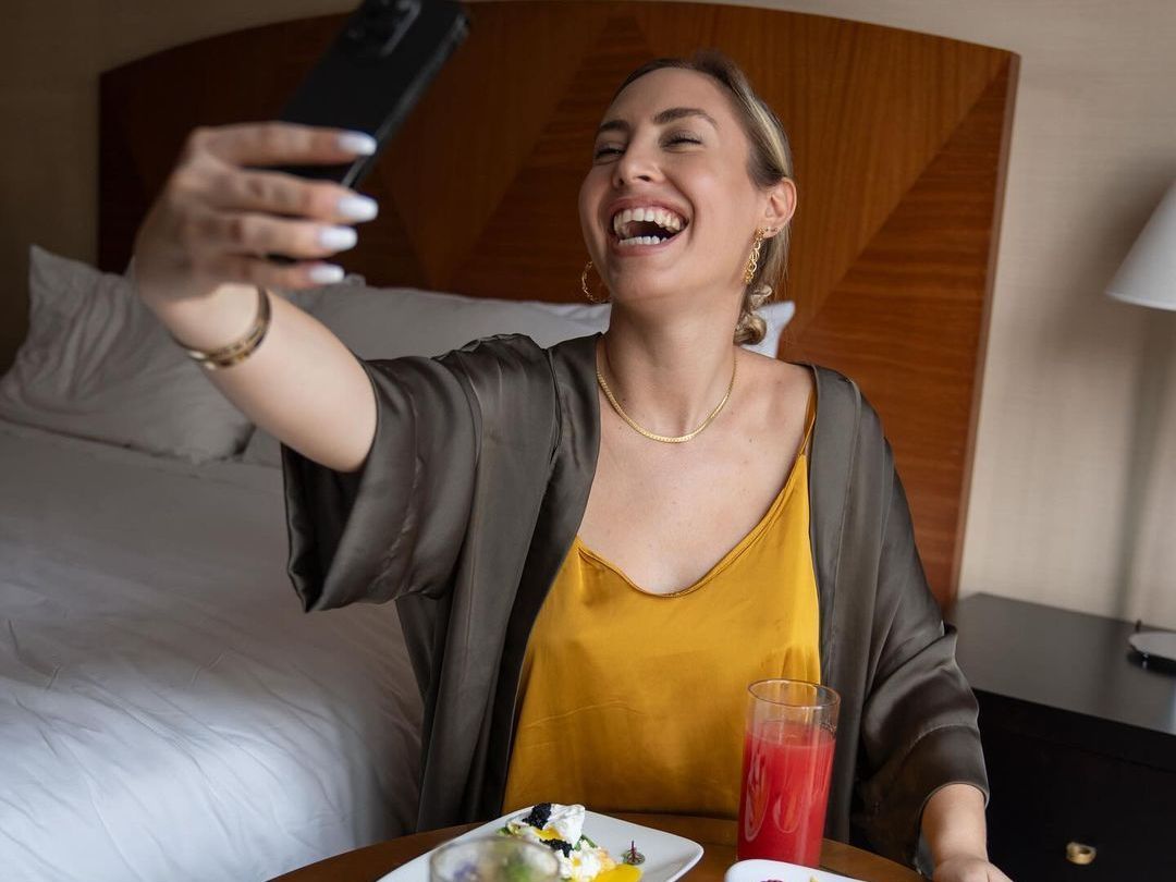 Una mujer se toma una selfie en una habitación de hotel.