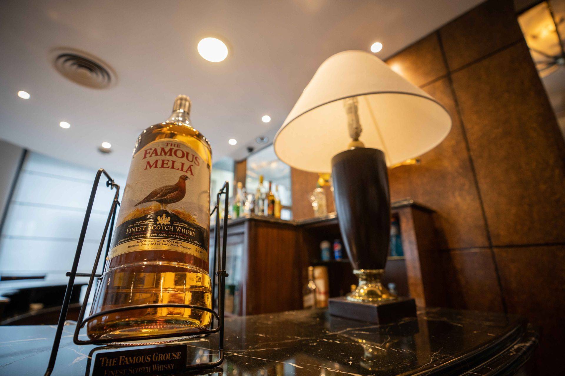 Una botella de humo mella está sobre una mesa al lado de una lámpara.