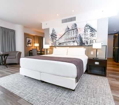 Una habitación de hotel con una cama tamaño king y un gran cuadro en la pared.
