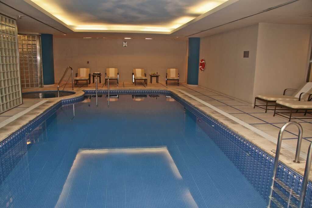 Una gran piscina cubierta con sillas alrededor.