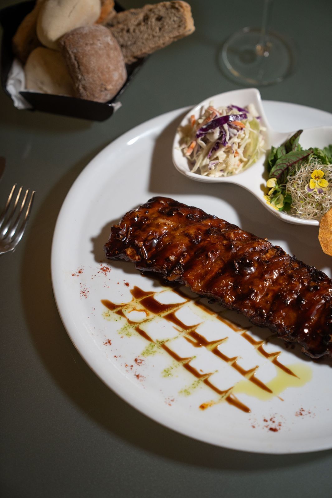 Un plato blanco cubierto con carne y verduras sobre una mesa.