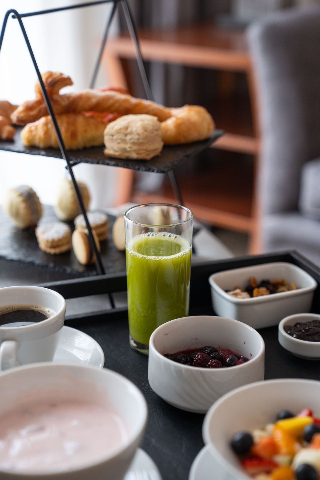 Una mesa cubierta con cuencos de comida y un vaso de jugo verde.