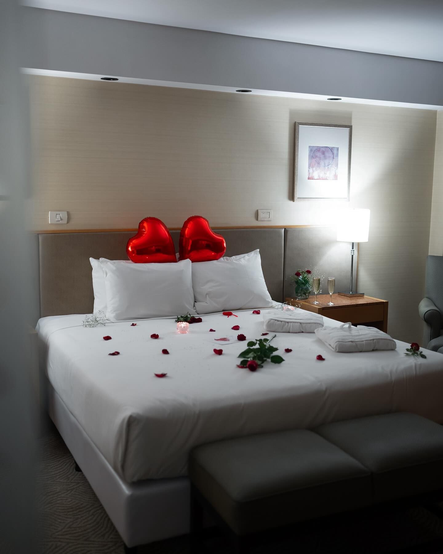 Una habitación de hotel con una cama decorada para el día de San Valentín.