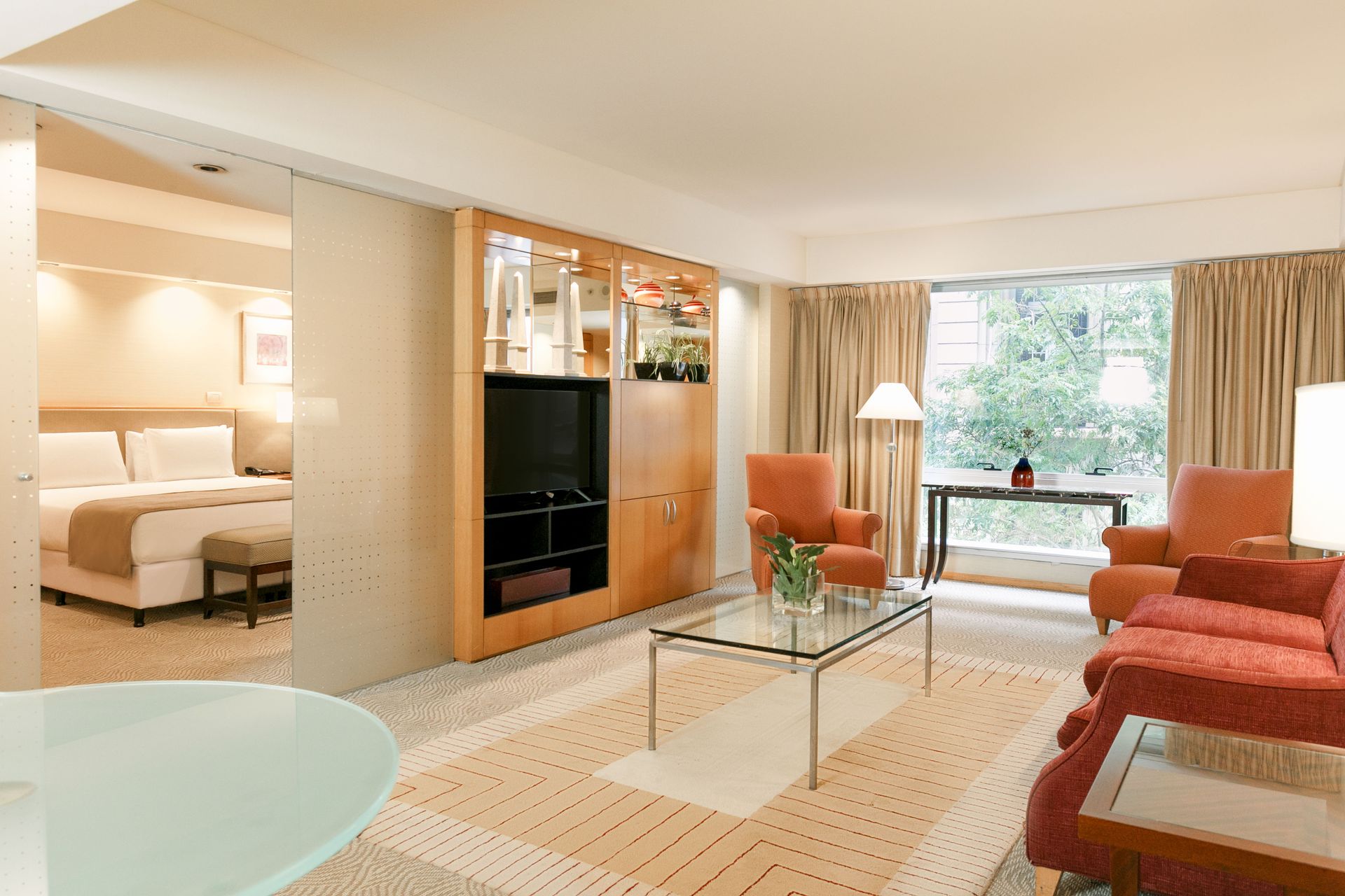 Una habitación de hotel con sofá, sillas, mesa y televisión.